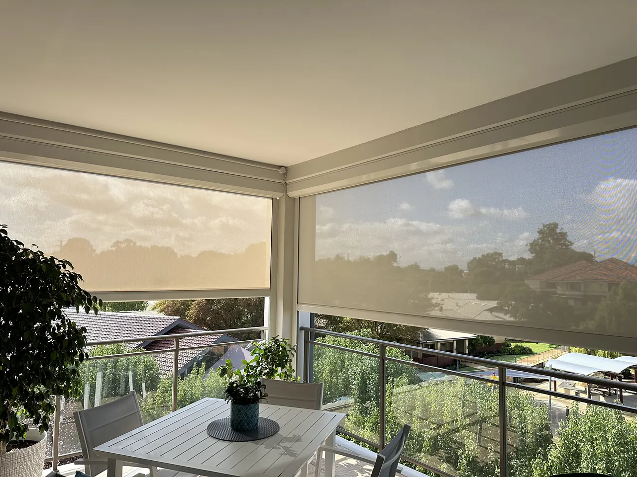 First-floor deck with zip blinds part-lowered against the afternoon sun