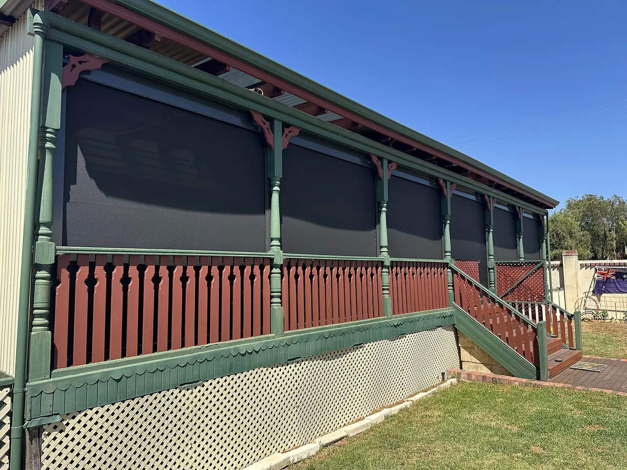Charcoal outdoor blinds on a heritage verandah with green lacework