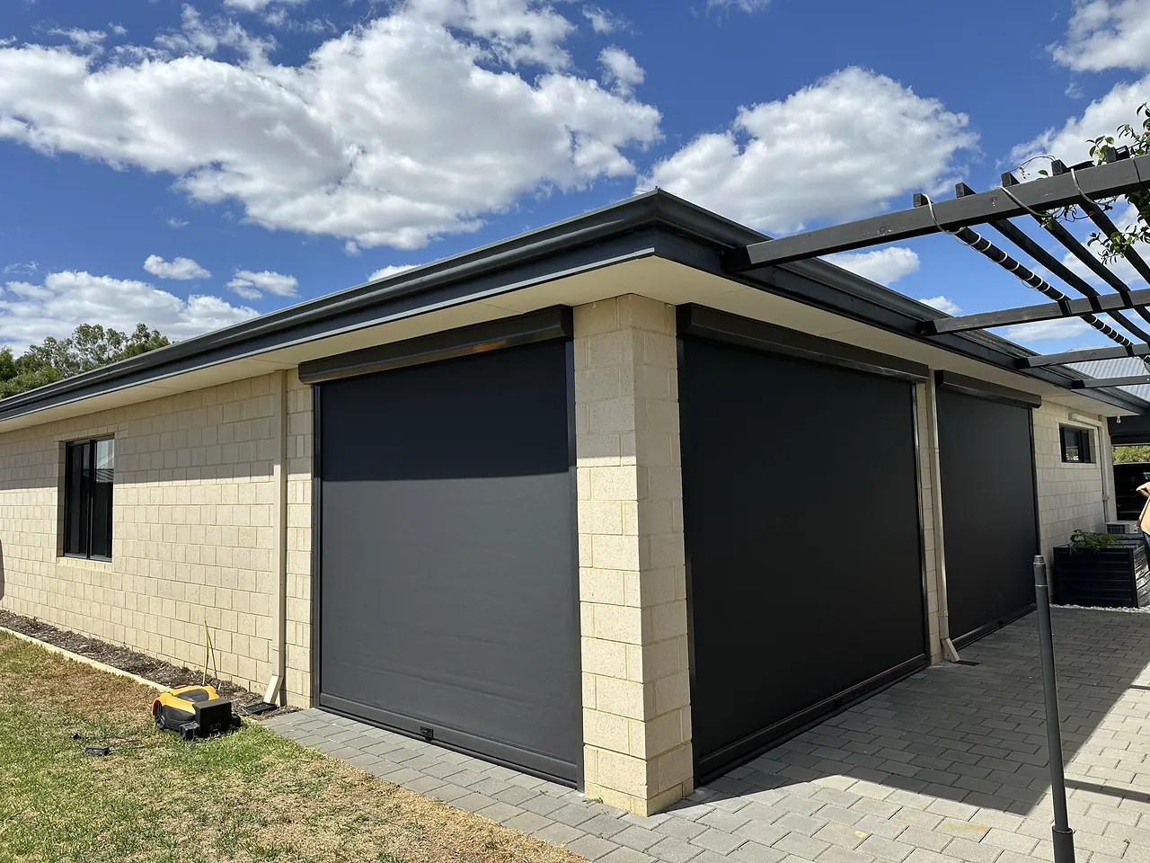 Charcoal zip blinds on a limestone alfresco under a pergola