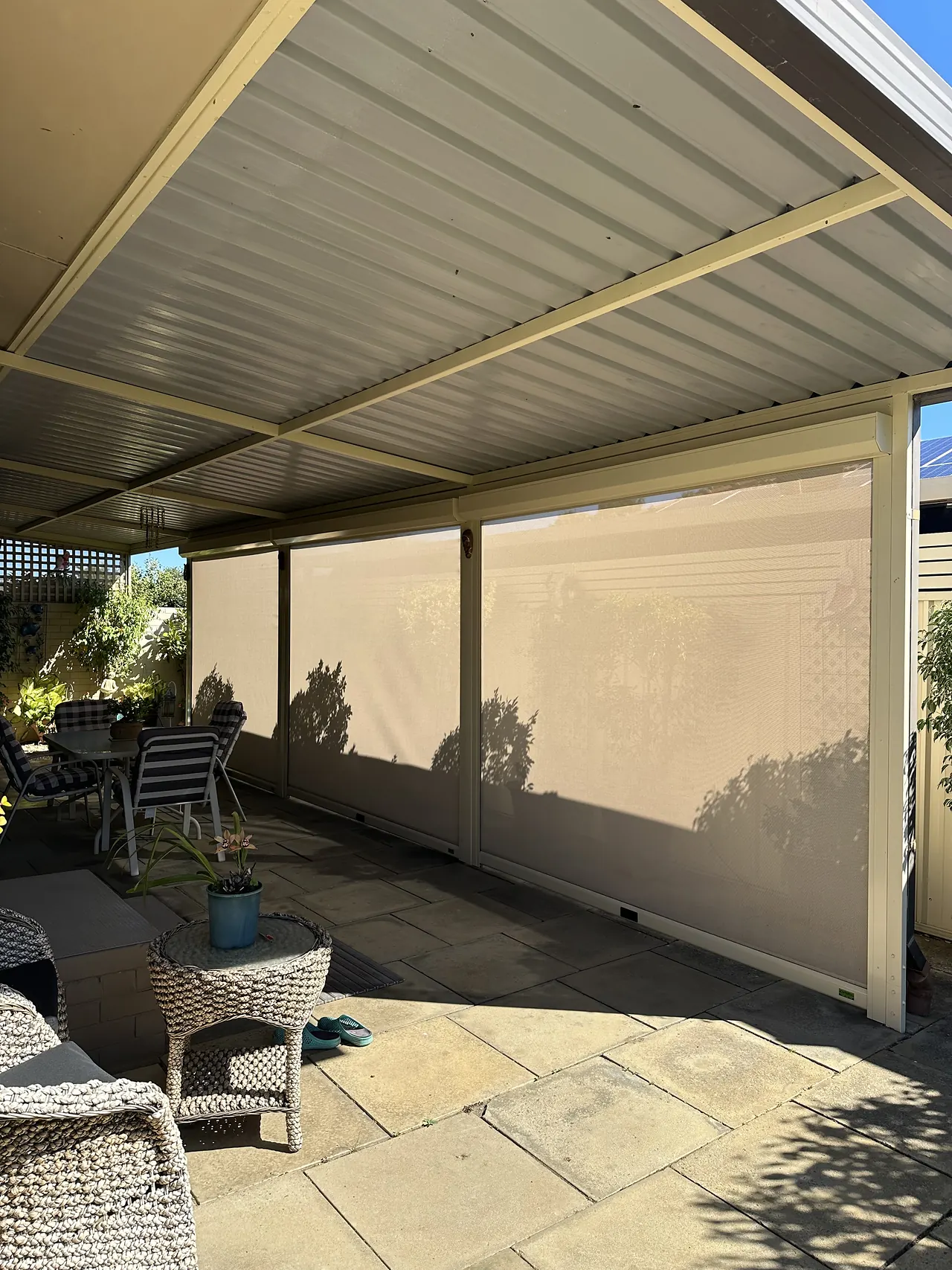 Sand-coloured blinds lowered around a patio lounge