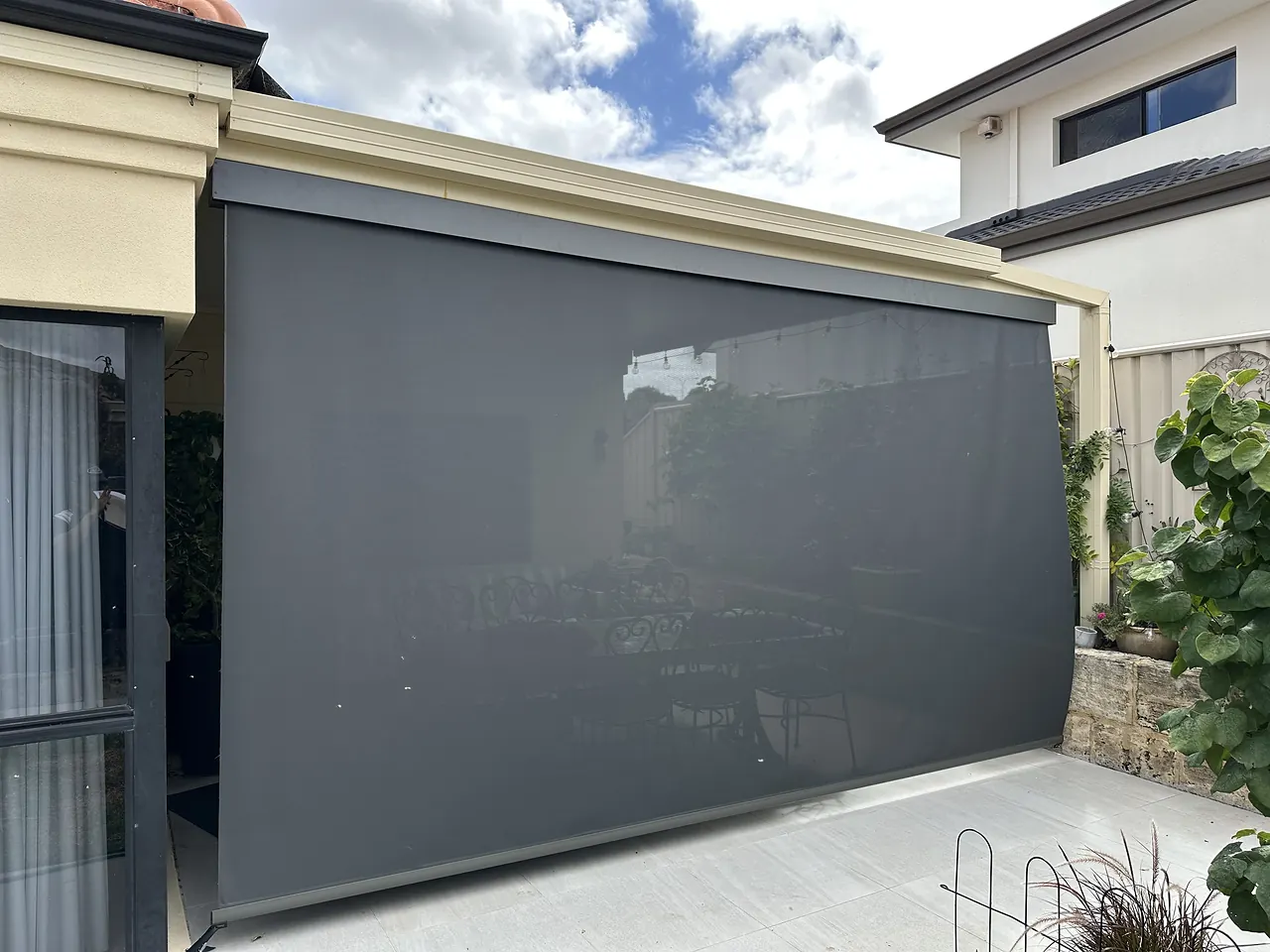 Charcoal zip blind screening a side courtyard