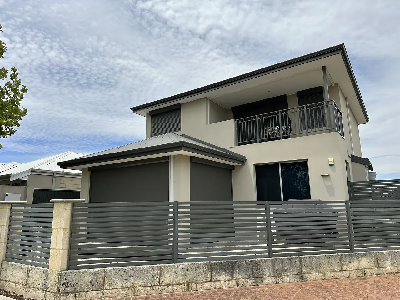 Two-storey home with charcoal blinds on the ground-floor alfresco