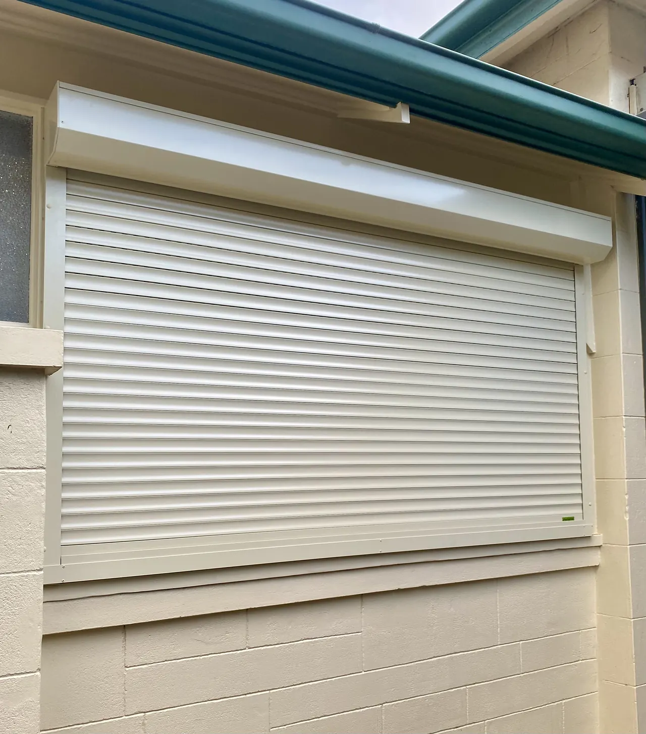 Cream roller shutter on a rendered window