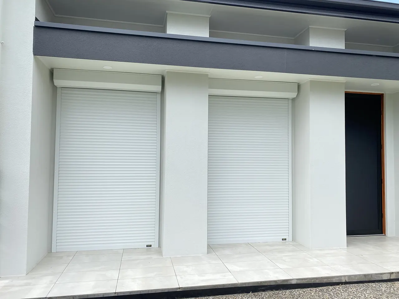White roller shutters on a modern rendered home