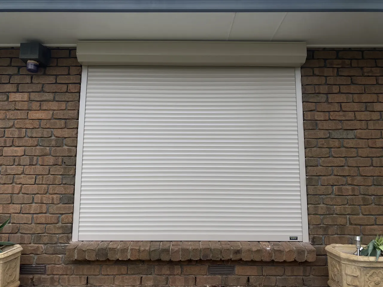 White roller shutter on a red brick home